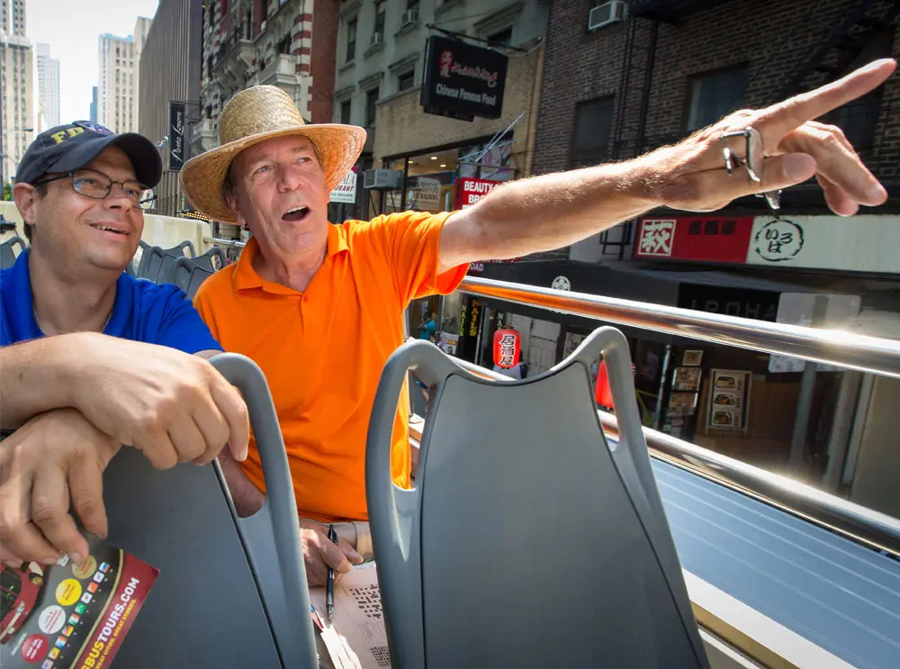 two-friends-on-board-a-big-bus-tour.webp